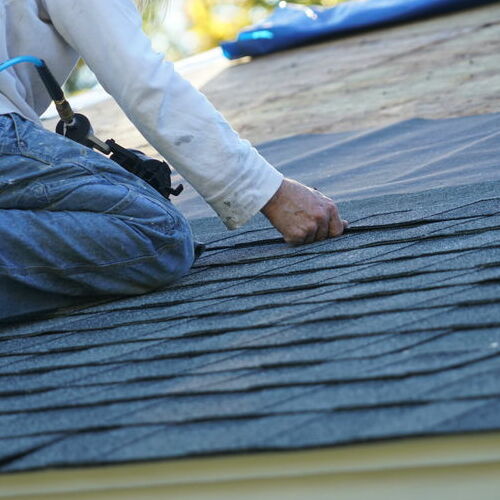 Roofer installs shingles