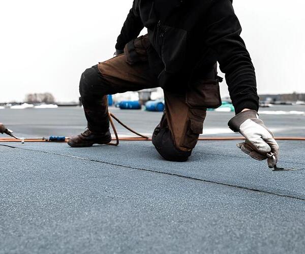 contractor installing modified bitumen roofing