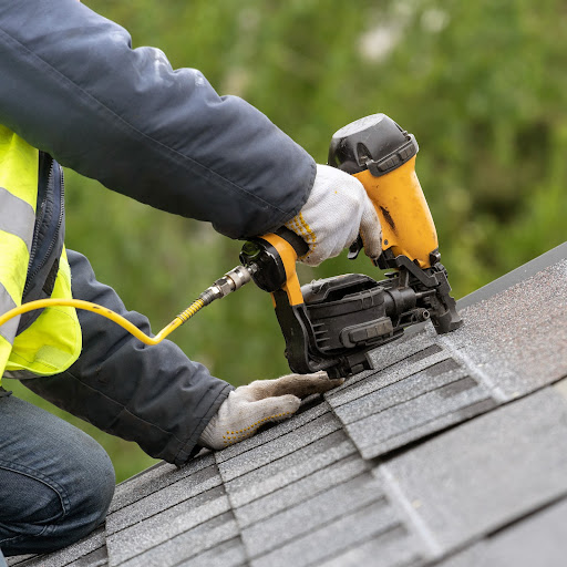 Roofer works on shingles.