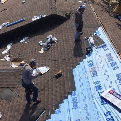 Roofers install shingles.