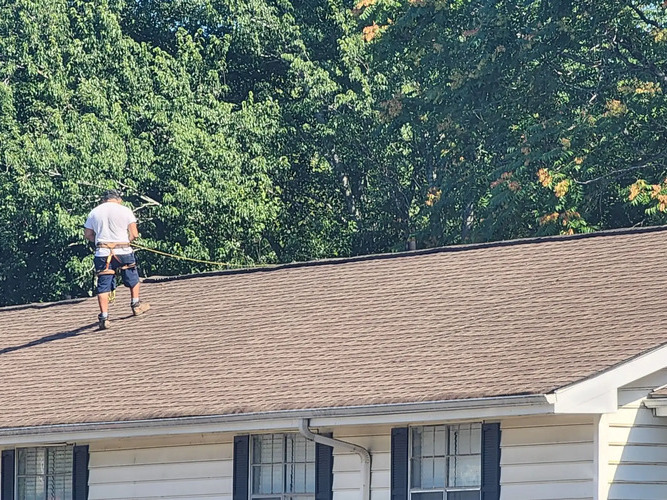 worker on a shingle roof