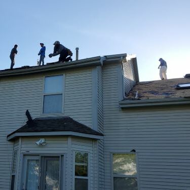 A roofer works on shingles