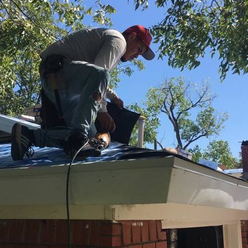Roofer installing shingles.